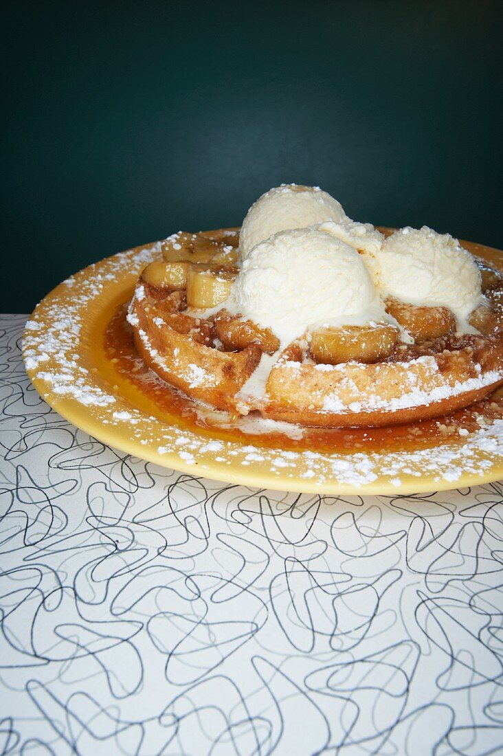 Banana Waffle Topped with Caramelized Bananas, Maple Syrup, Ice Cream and Powdered Sugar