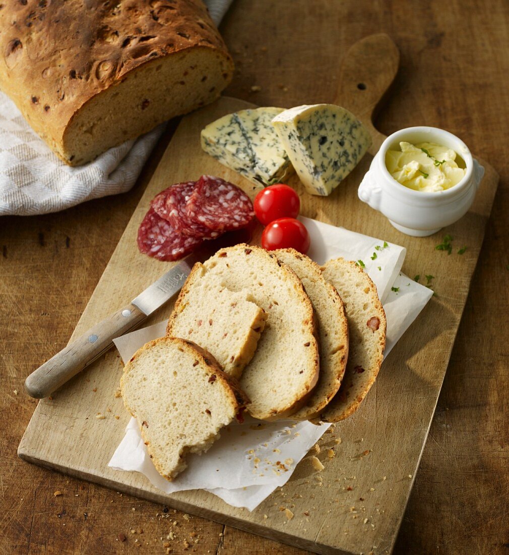 Brotzeitbrett: Speck-Zwiebel-Brot, Hartwurst, Blauschimmelkäse, Butter und Tomaten