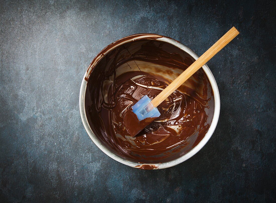 Leftover Melted Chocolate in a Metal Mixing Bowl with a Rubber Spatula