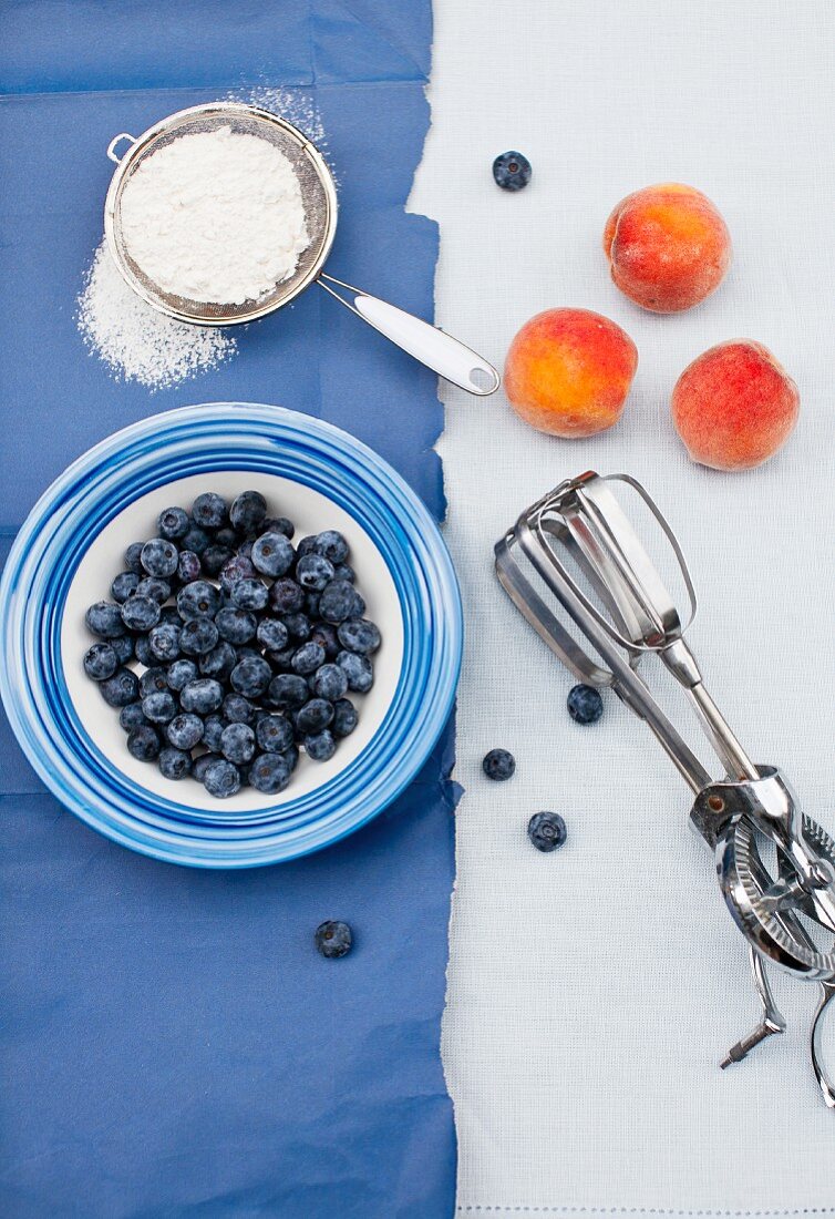 Frische Blaubeeren und Pfirsiche, Handmixer und Puderzucker