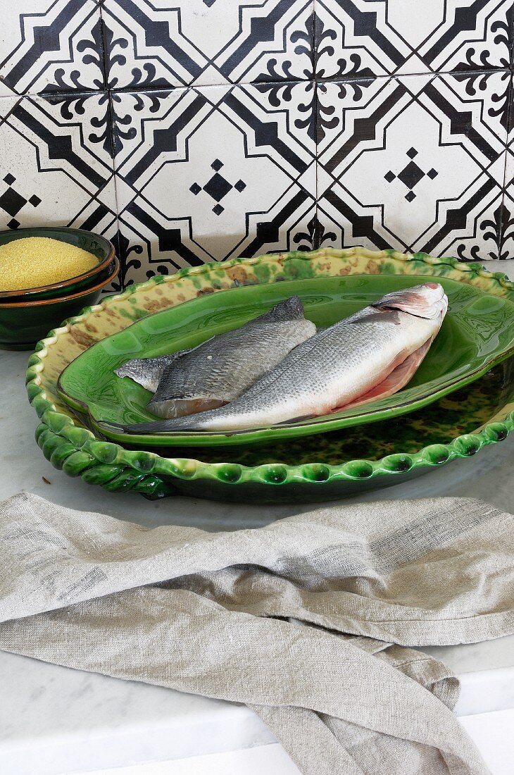 Rohe Fische auf grünem Keramikteller