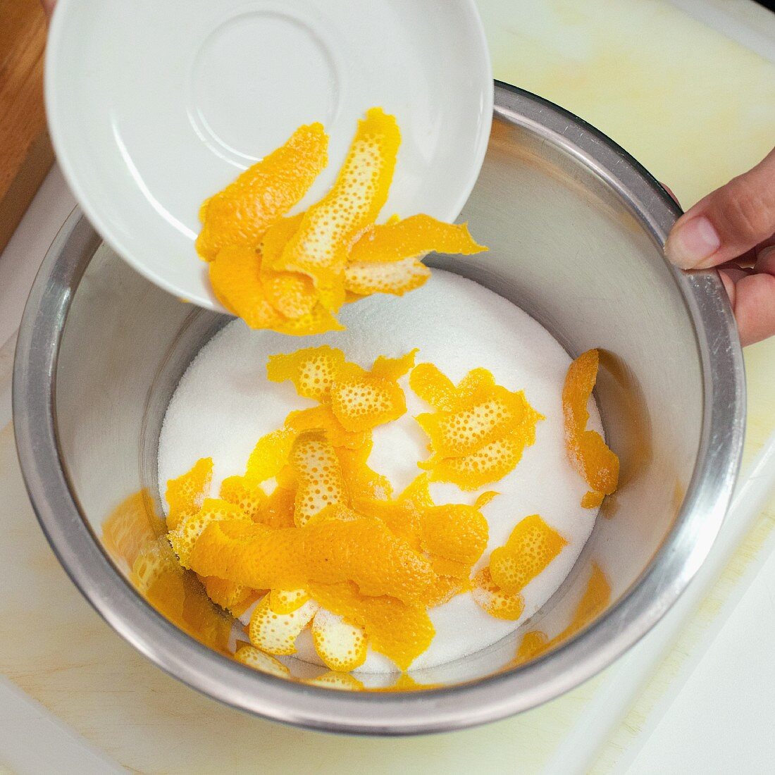 Orange peel being added to sugar to make orange and lavender sugar