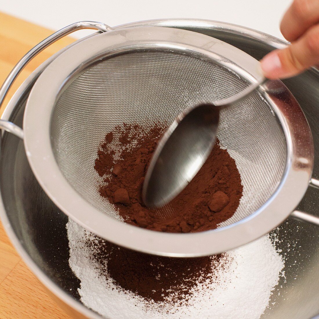 Cocoa being pressed through a sieve for making winter-spiced cream liqueur