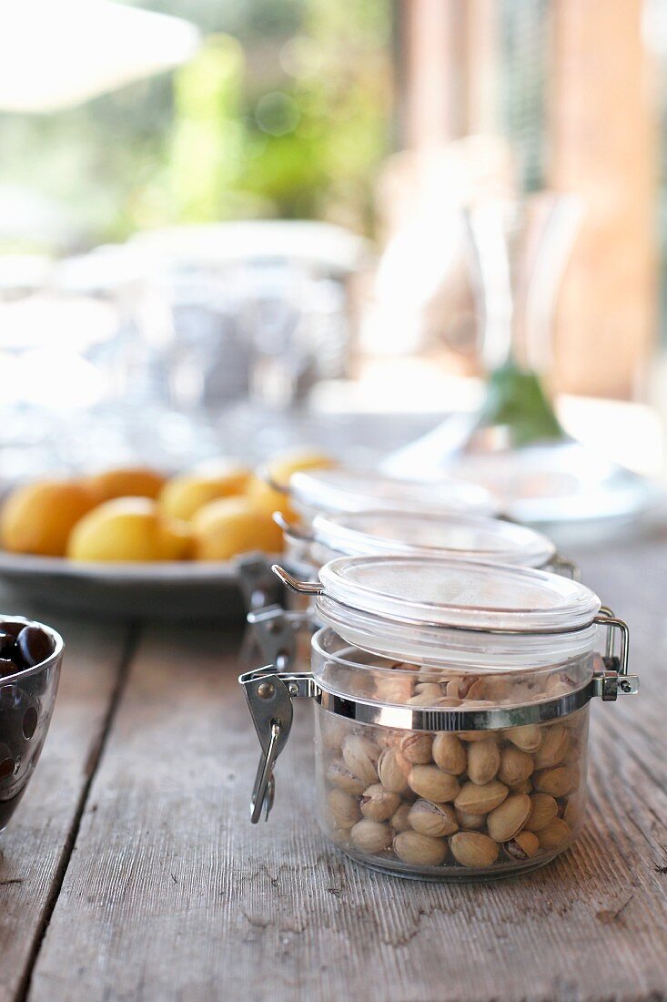 Pistachios in a jar on a wooden table outdoors