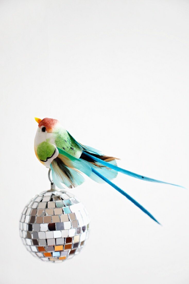 Colourful bird ornament on mosaic mirror disco ball