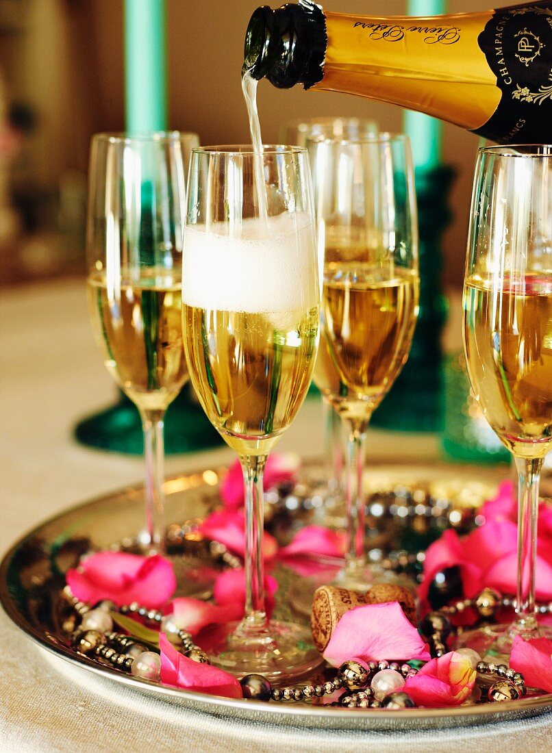 Champagner in Gläser einschenken