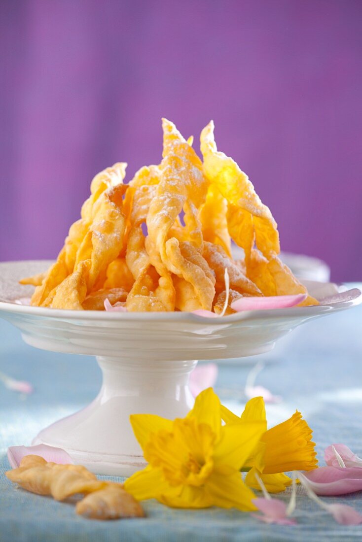 Faworki (pastries from Poland) with icing sugar on a cake stand