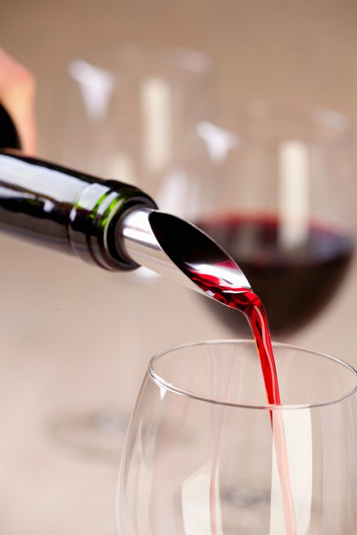 Rotwein in ein Glas einschenken