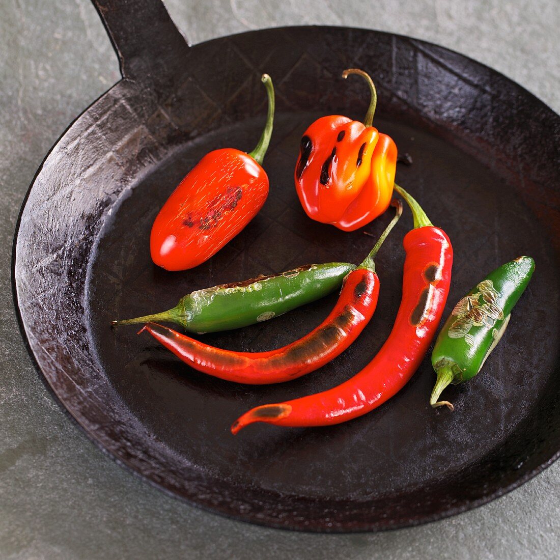 Whole peppers toasted in a pan