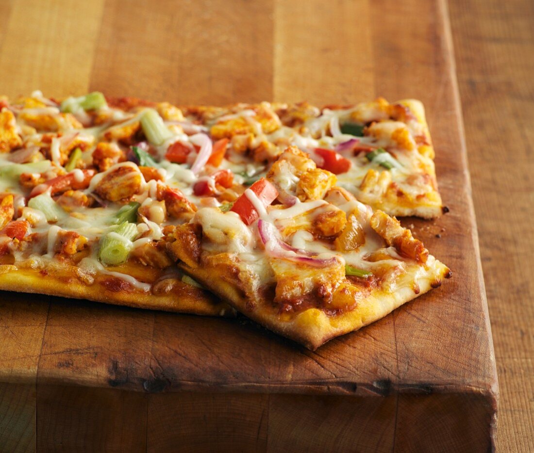 Pizza with curried chicken, peppers and spring onions