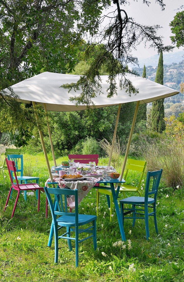 Gedeckter Tisch im Garten unter einem Sonnensegel