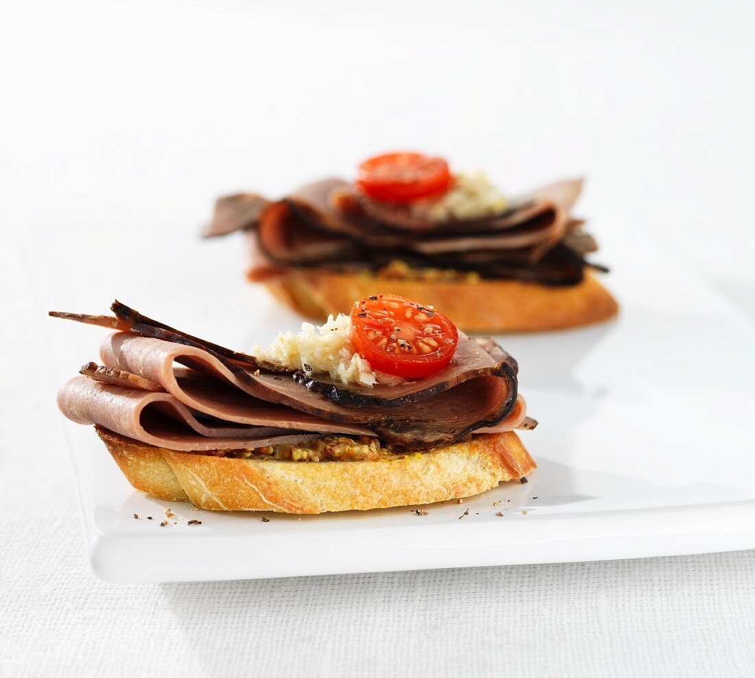 Crostini with sliced beef and cherry tomatoes