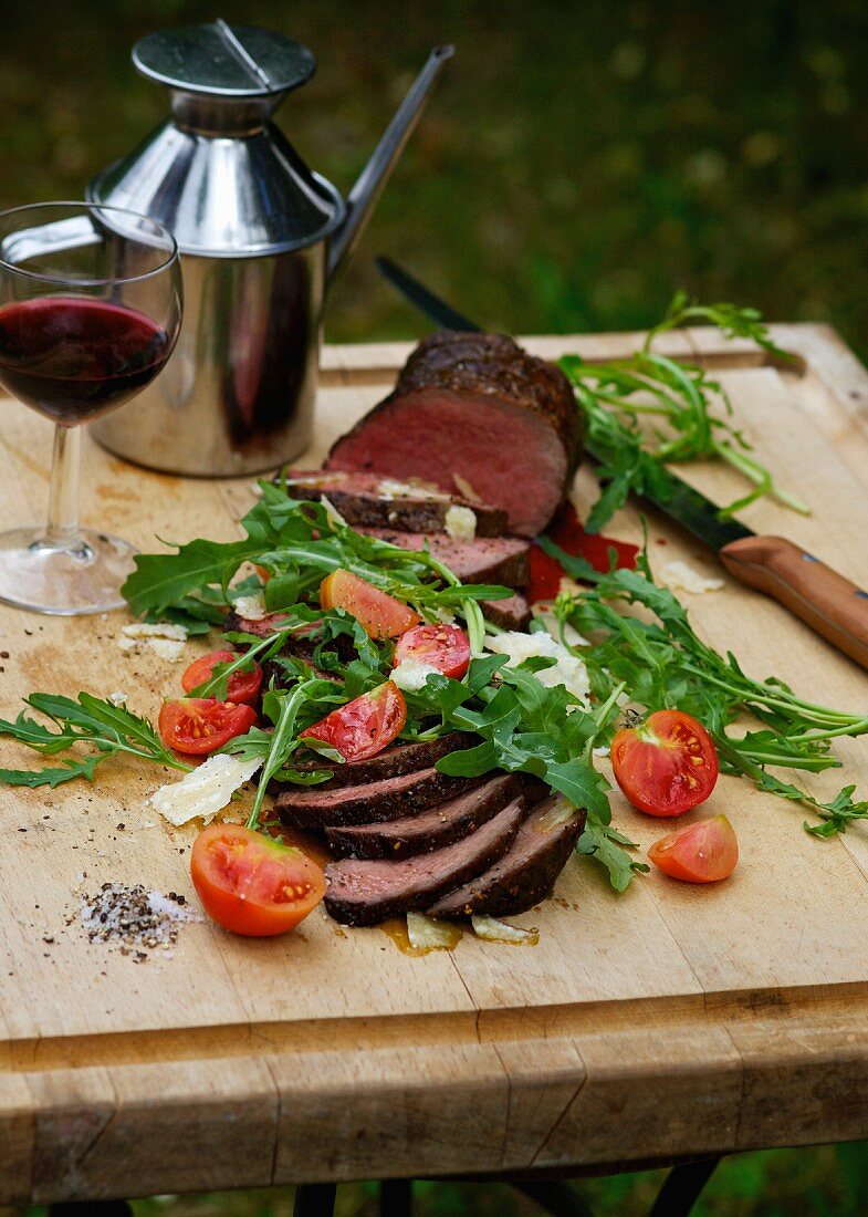 Sirloin of beef with rocket, tomatoes and parmesan at a barbecue