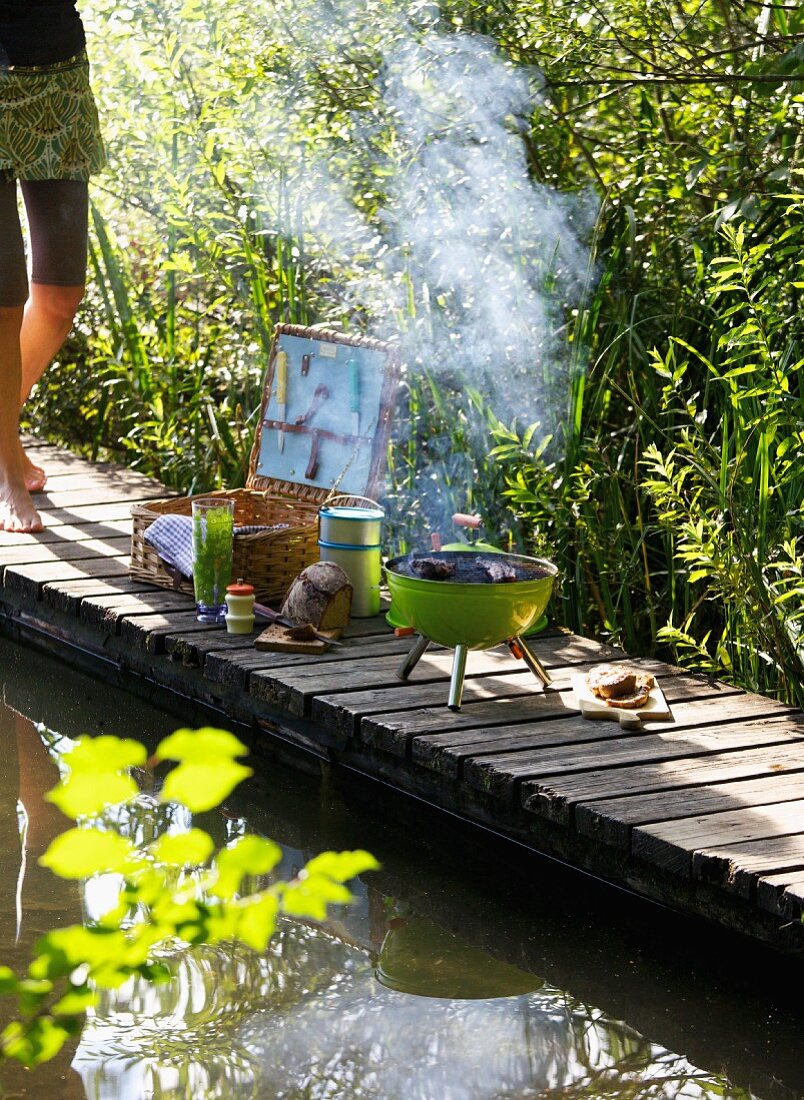A barbecue picnic on a wooden jetty on the bank of a lake