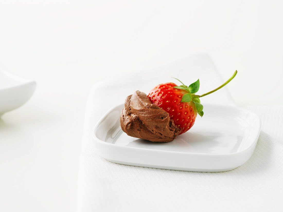 A strawberry dipped in chocolate mousse