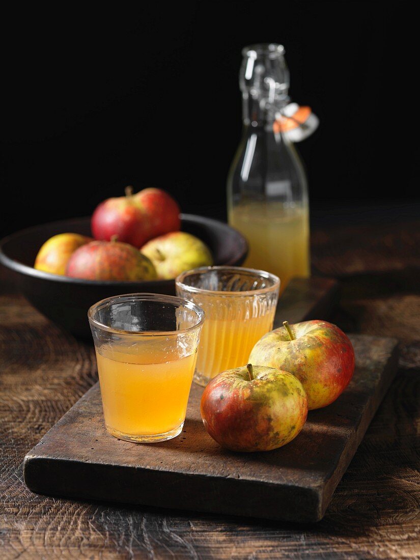 Äpfel & Apfelsaft in Gläsern auf Holzbrett