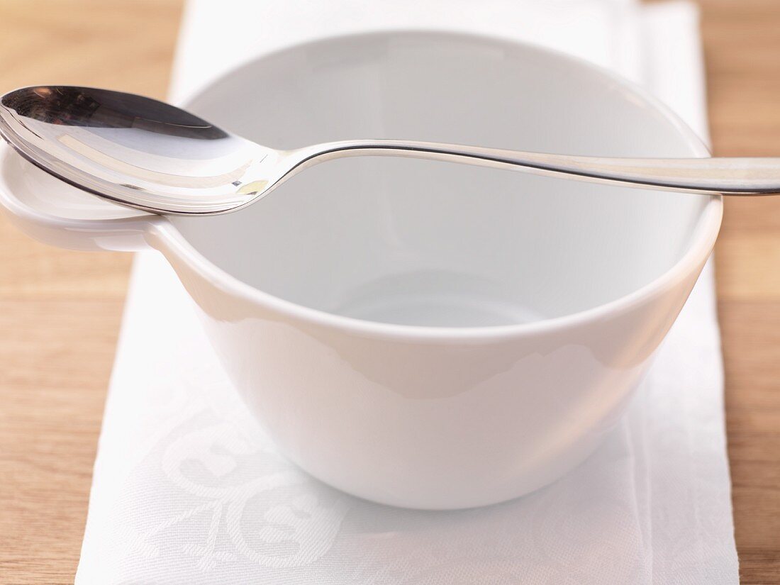 An empty soup bowl and spoon