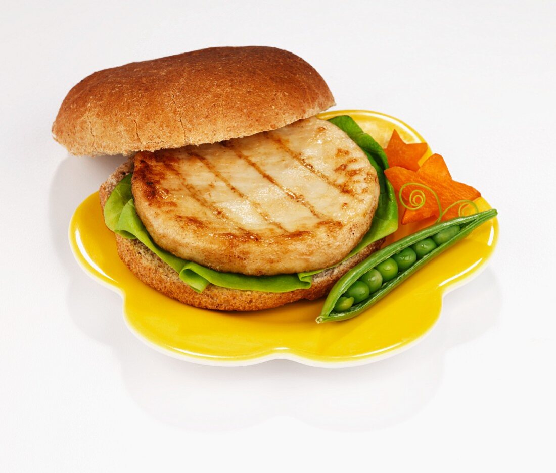 Chicken burger garnished with a fresh pea pod