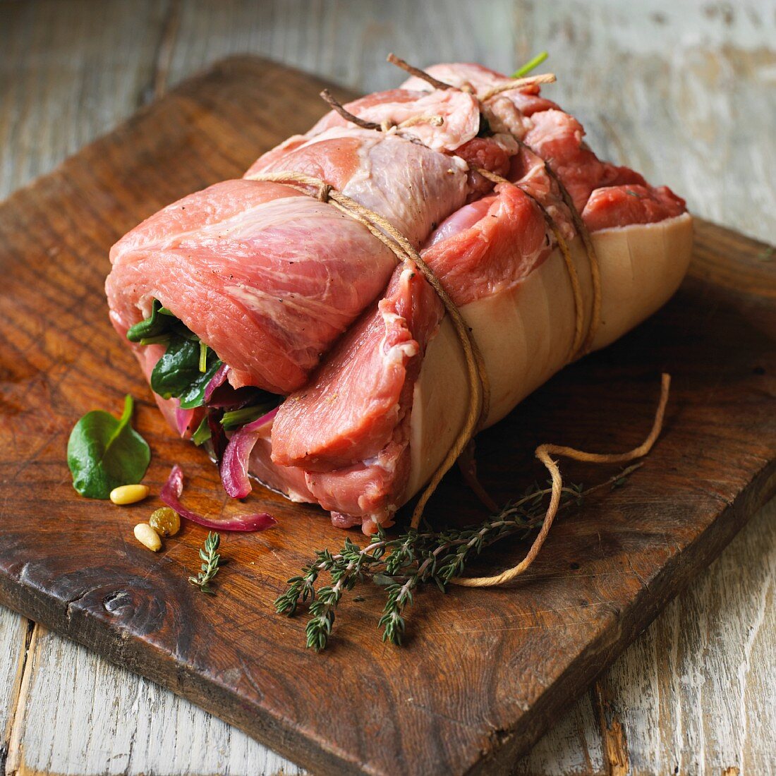 Stuffed, rolled pork shoulder on a chopping board