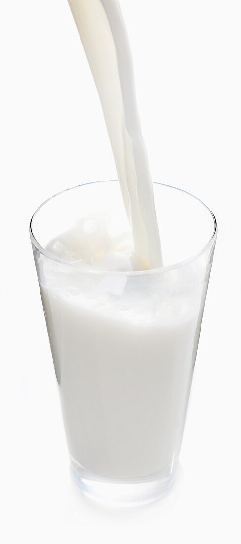 Milch in ein Glas eingiessen