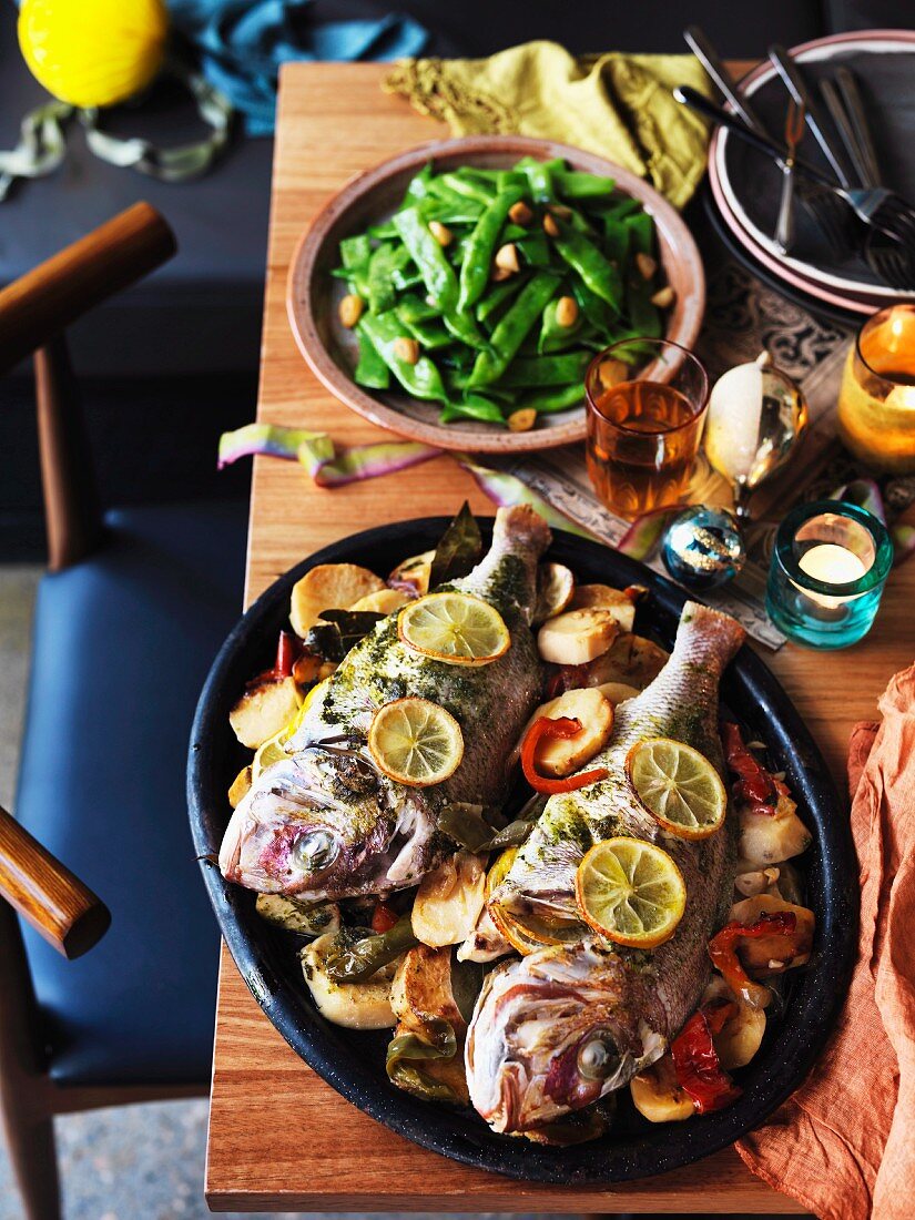 Two snappers with potatoes and peppers, and beans with preserved garlic for Christmas (Spain)