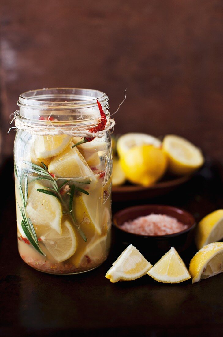 Eingelegte Zitronen mit Rosmarin und Chilischoten im Einmachglas