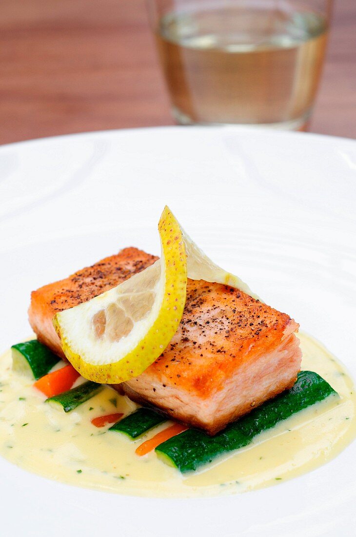 Pan-fried salmon on white wine sauce with vegetables