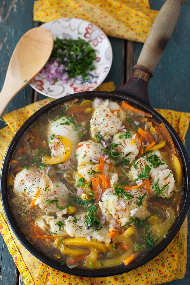 Fischeintopf mit Möhren und Paprika in einer Pfanne (Draufsicht)