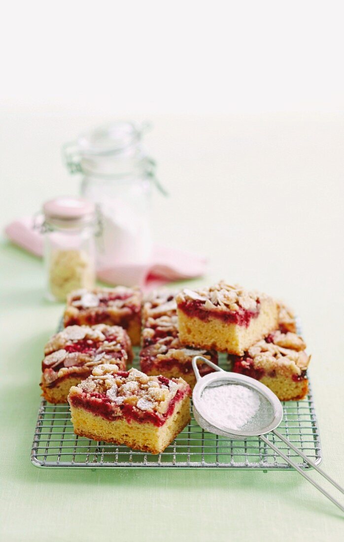 Raspberry and vanilla slices with crumble topping and icing sugar