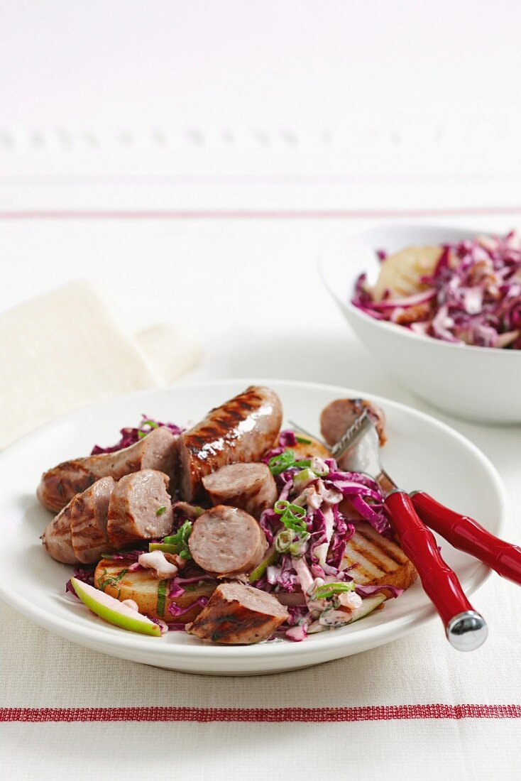 Bratwurst sausages with barbecued potatoes and red cabbage salad