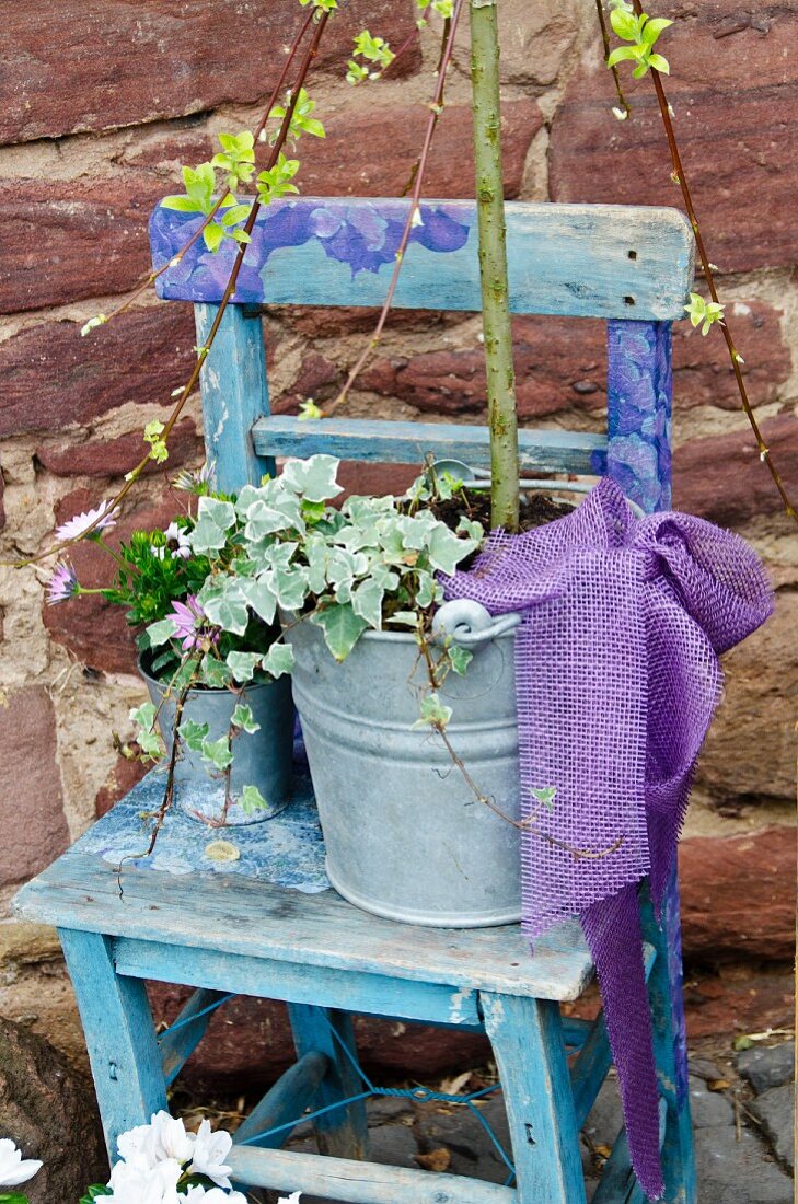 Blauer Stuhl mit Pflanzen in Zinkgefässen