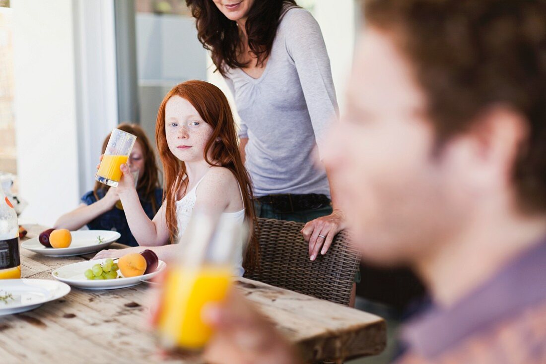 Familie trinkt Orangensaft zum Frühstück
