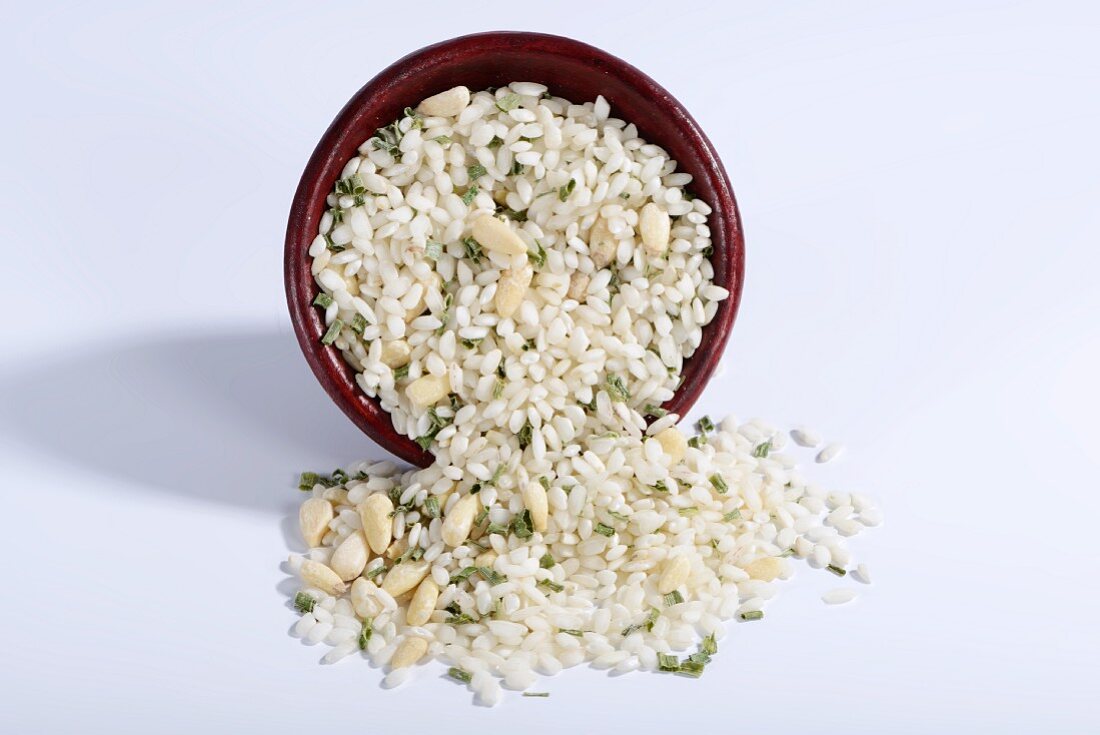 Vialone Nano risotto rice with pine nuts and chives in a ceramic bowl