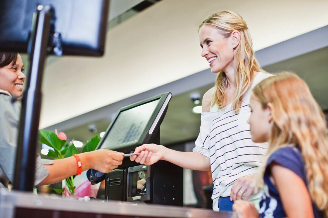 Frau bezahlt mit Kreditkarte im Supermarkt