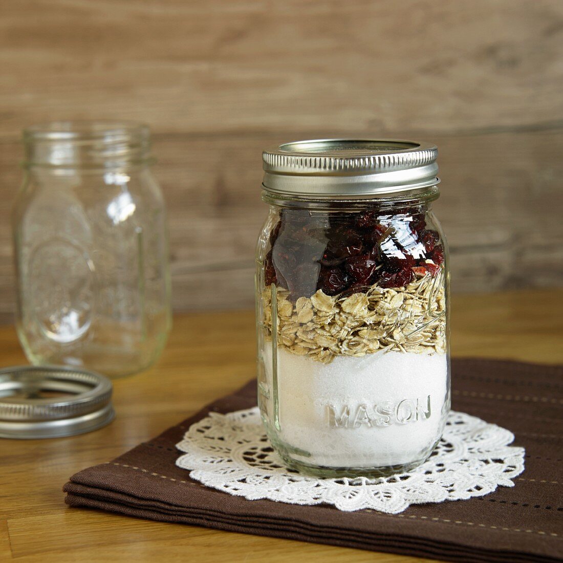 A jar containing dry ingredients for making oatmeal and cranberry biscuits