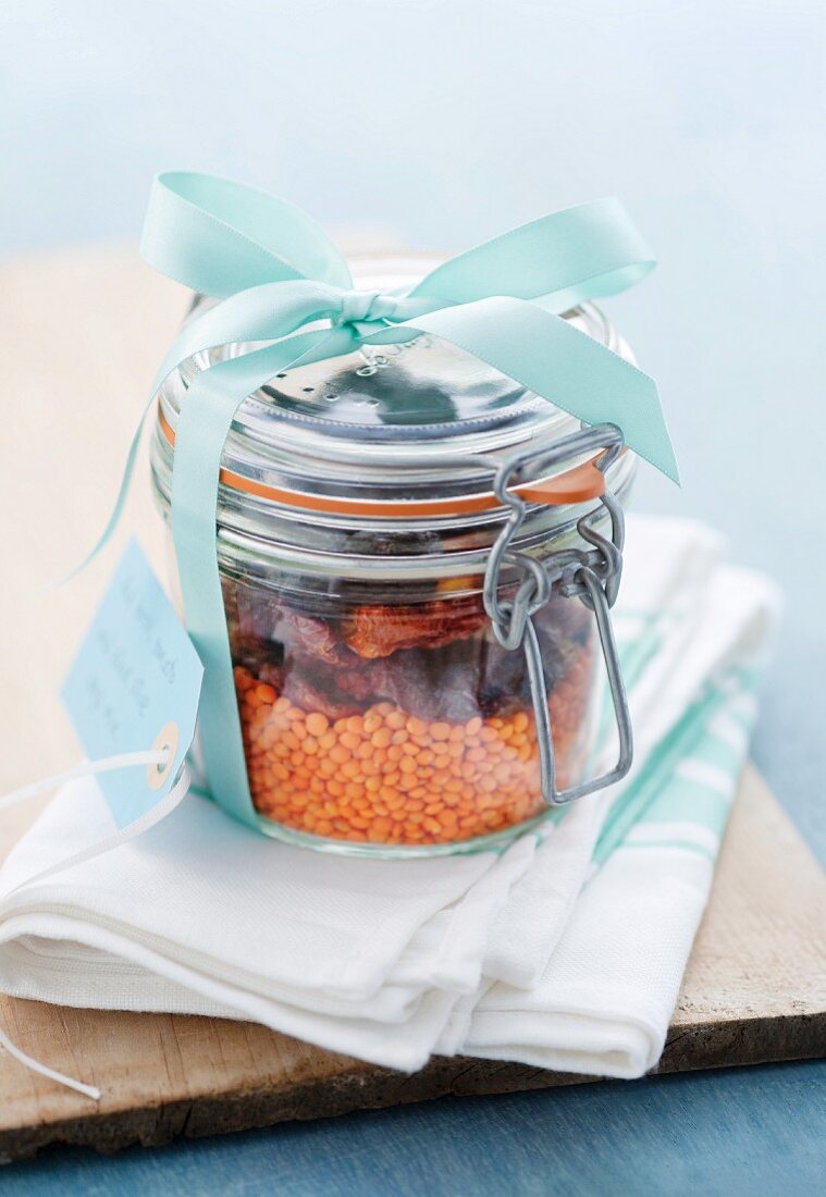 Trockene Zutaten für Linsensuppe mit getrockneten Tomaten und Oliven in einem Einmachglas