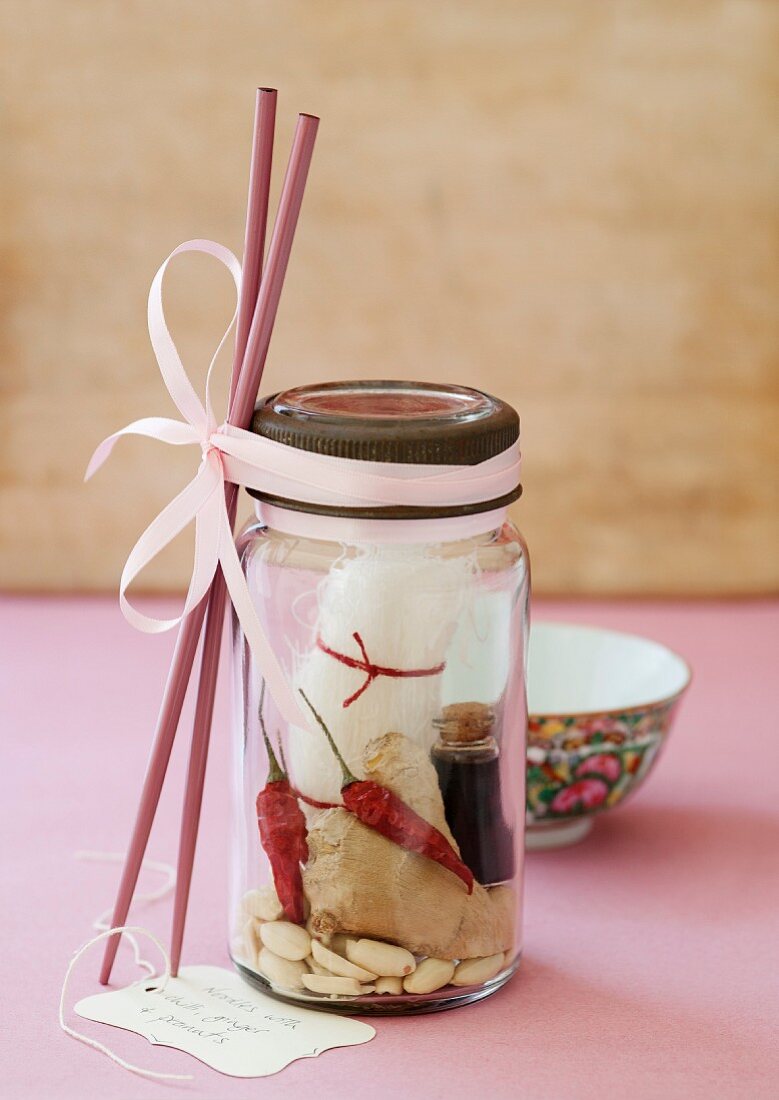 Glasnudeln mit Ingwer, Chili, Erdnüsse und eine kleine Flasche Sojasauce in einem Schraubglas mit Essstäbchen