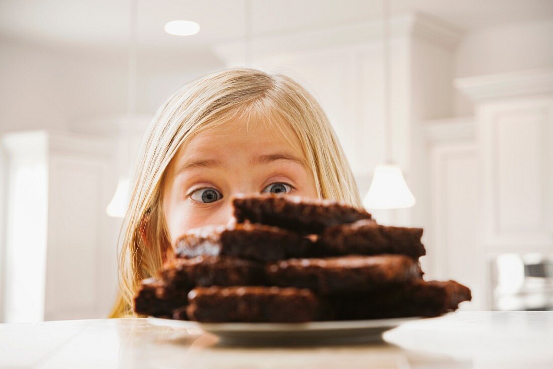 Girl (6-7) looking at heap of brownies
