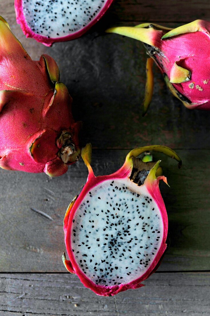 Whole and halved red dragon fruit (view from above)