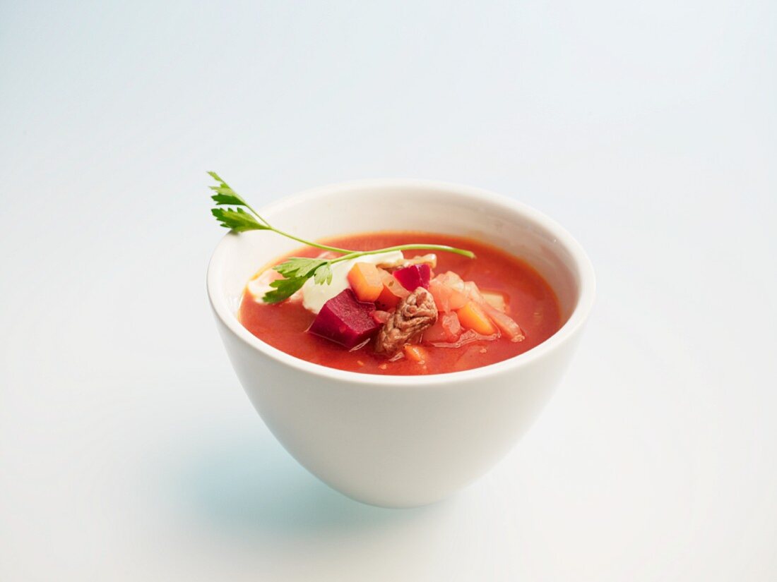Borscht in a small bowl against a white background