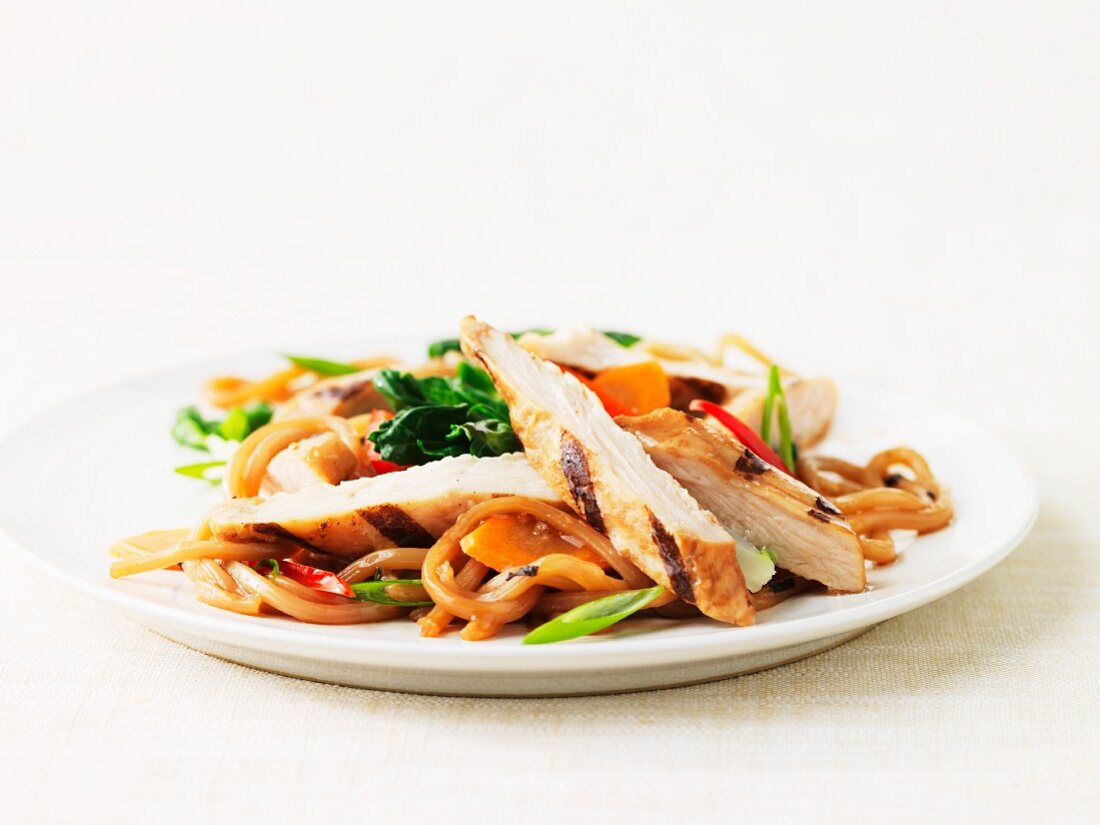 Grilled turkey strips on a bed of soba noodles with vegetables