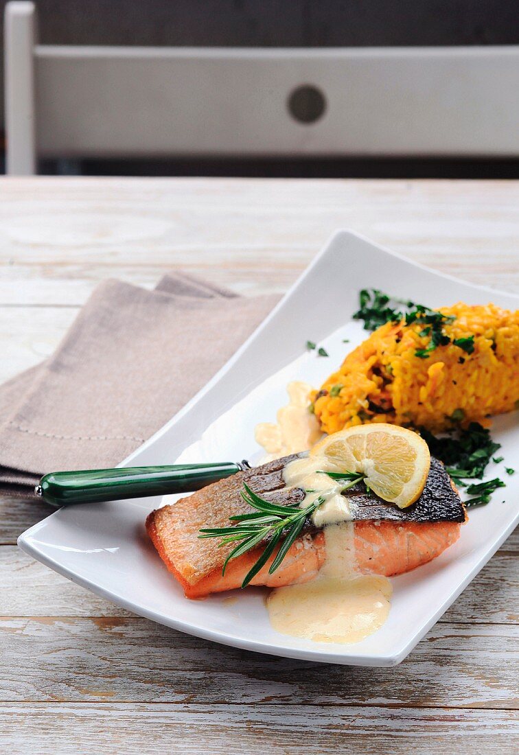 Grilled salmon with rosemary and lemon sauce served with yellow risotto