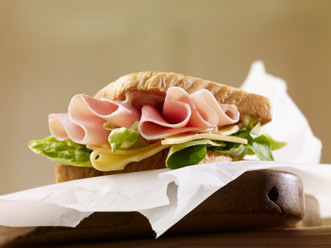 A sandwich filled with ham, cheese and lettuce