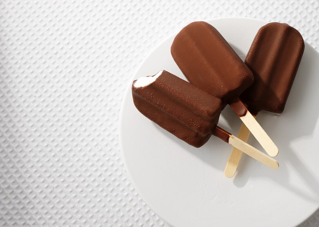 Three ice lollies coated in chocolate