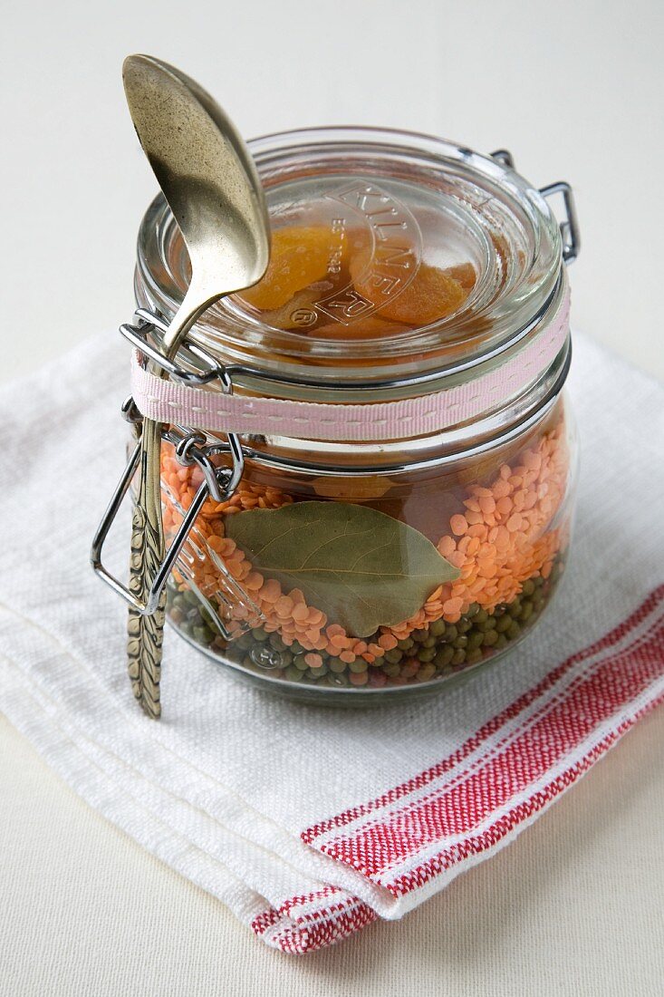 Trockene Zutaten für Linsen-Bohnen-Suppe in einem Geschenkglas