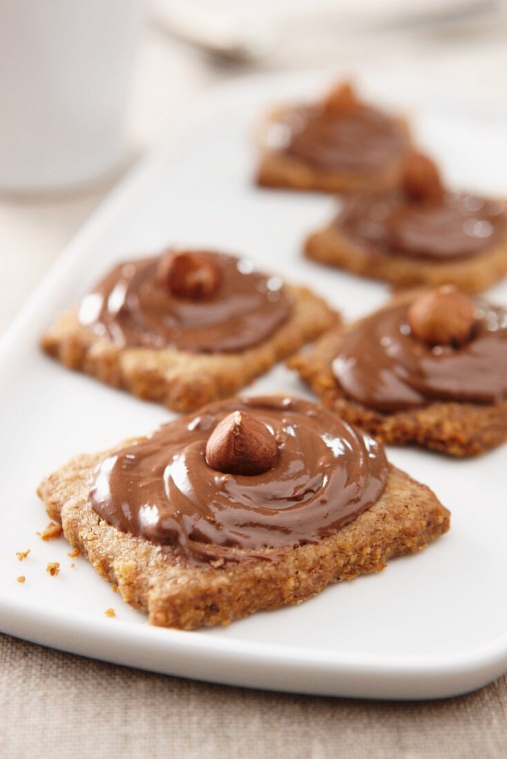 Cappuccino biscuits topped with chocolate and hazelnut spread and hazelnuts