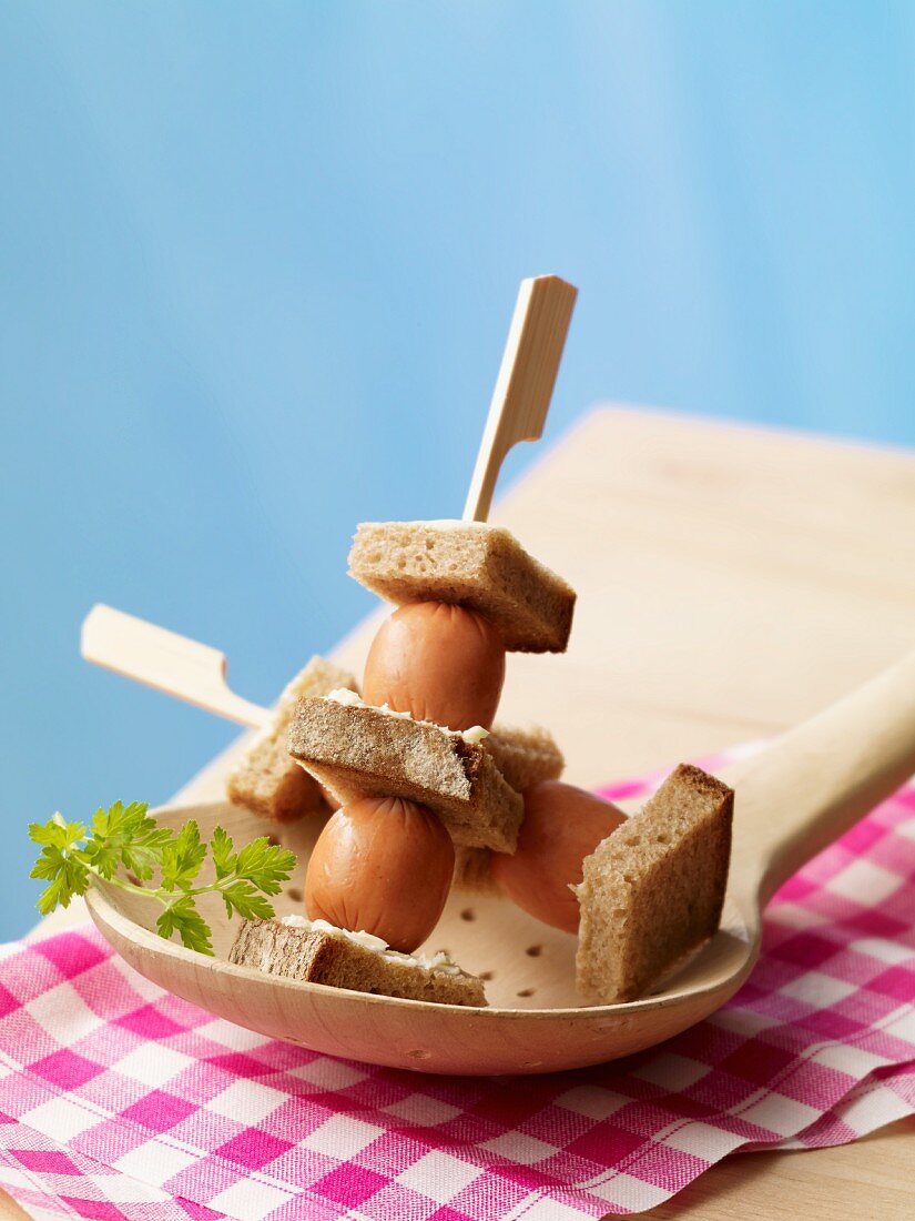 Skewers of mini bockwurst sausages with bread and butter