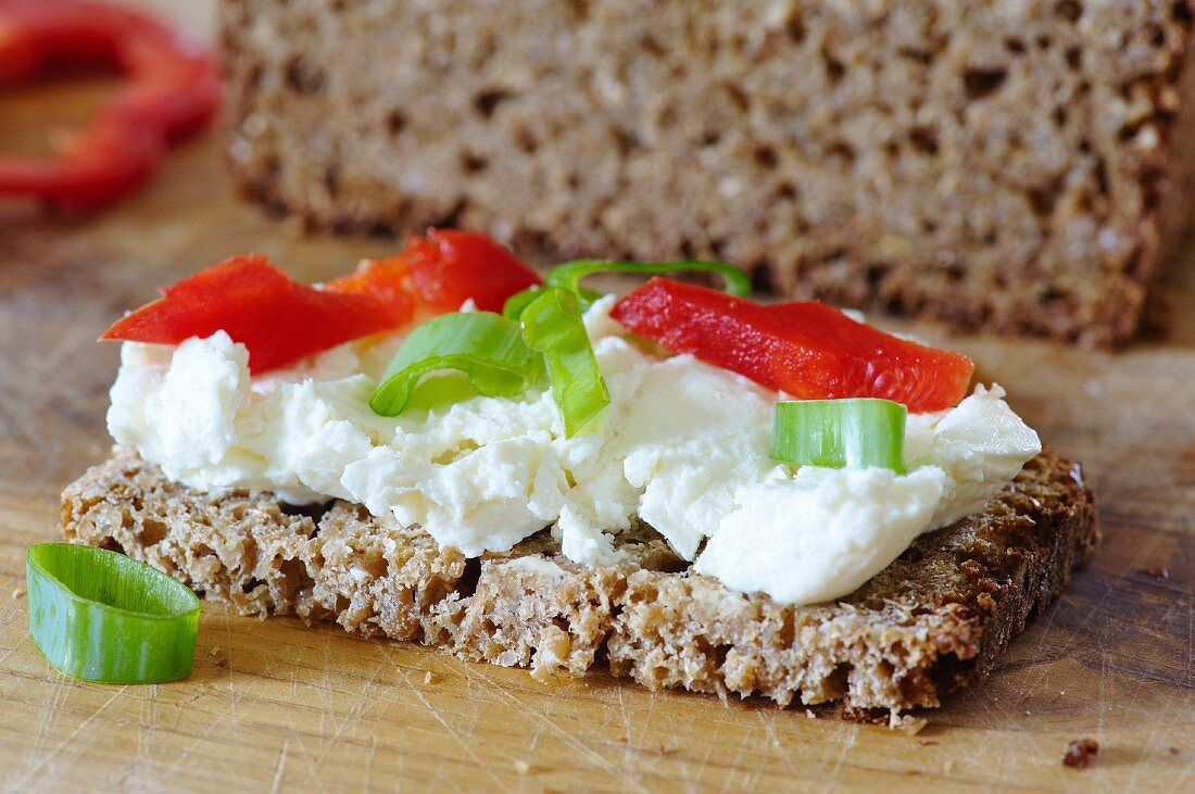 A slice of wholemeal bread topped with cottage cheese and vegetables