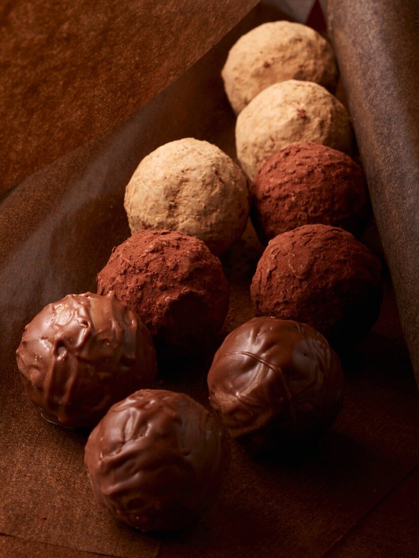 Assorted chocolate truffles on grease-proof paper