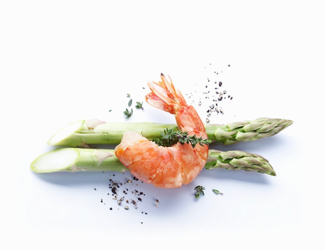 A prawn on two stalks of green asparagus